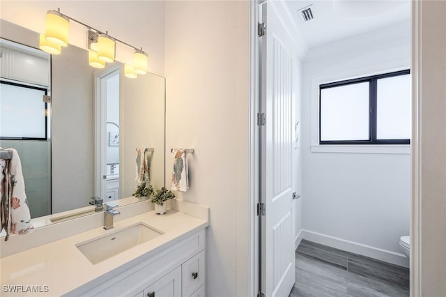 bathroom with wood-type flooring, toilet, and vanity