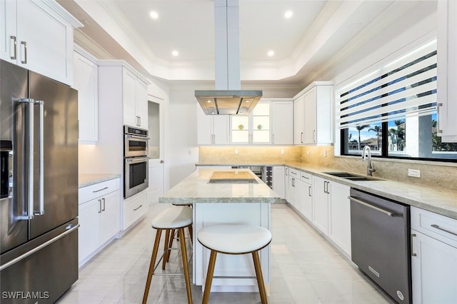 kitchen with white cabinetry, appliances with stainless steel finishes, light stone counters, and a center island