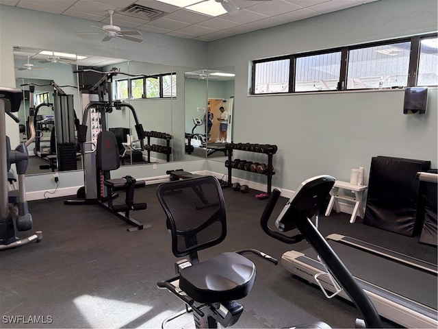 exercise room with a paneled ceiling and ceiling fan