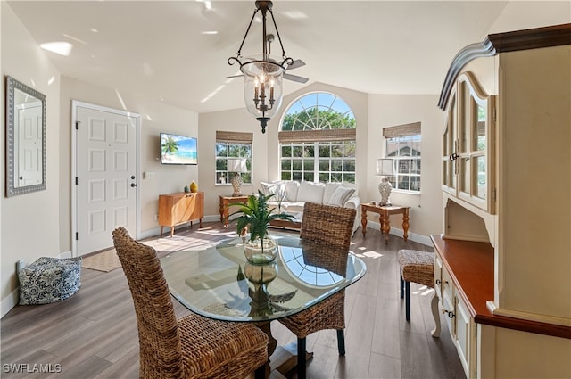 dining space featuring an inviting chandelier, light hardwood / wood-style flooring, and vaulted ceiling