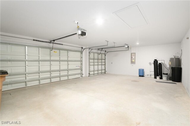 garage featuring electric panel, water heater, and a garage door opener