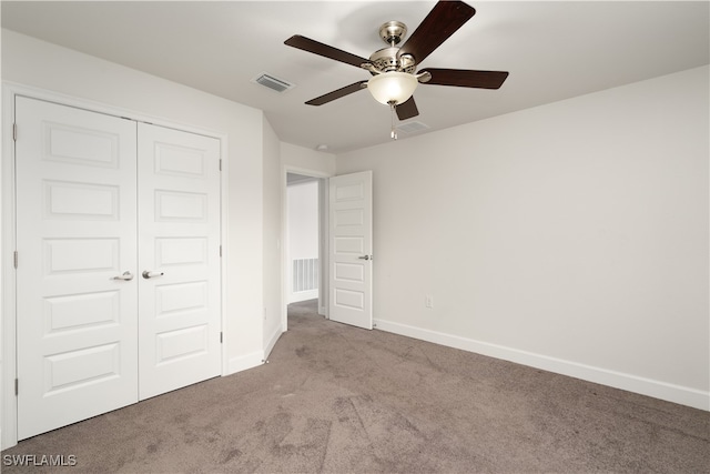 unfurnished bedroom with ceiling fan, light carpet, and a closet