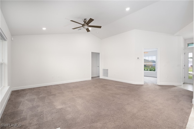 carpeted spare room with ceiling fan and high vaulted ceiling