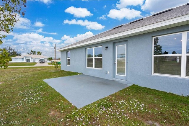 rear view of house with a lawn and a patio area