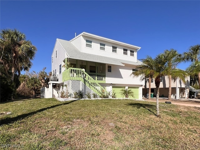 view of front facade with a front lawn, a garage, central air condition unit, and covered porch