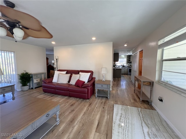 living room featuring light hardwood / wood-style floors and ceiling fan