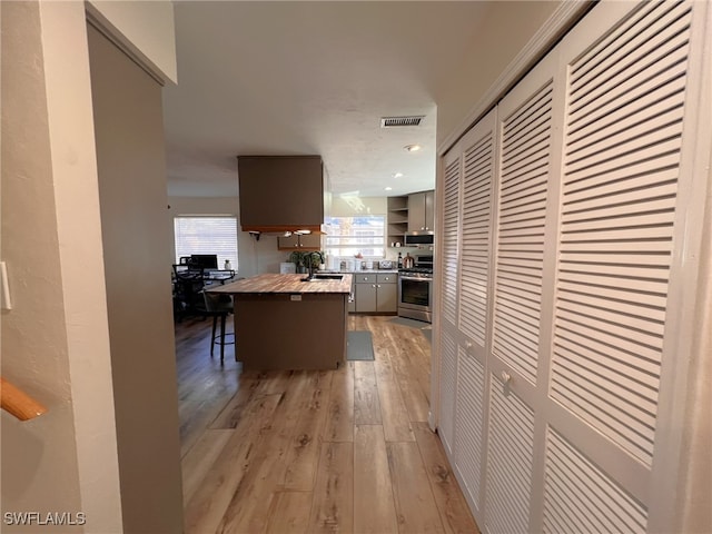 hall with light hardwood / wood-style floors and sink