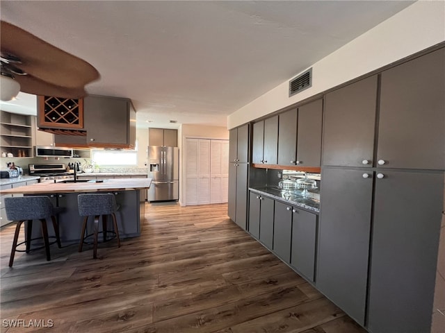 kitchen featuring gray cabinets, sink, wood-type flooring, and stainless steel appliances