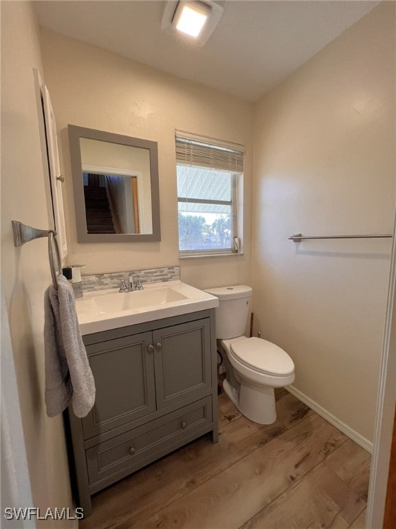 bathroom with vanity, hardwood / wood-style flooring, and toilet