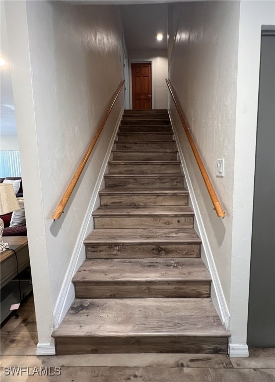 staircase with hardwood / wood-style flooring