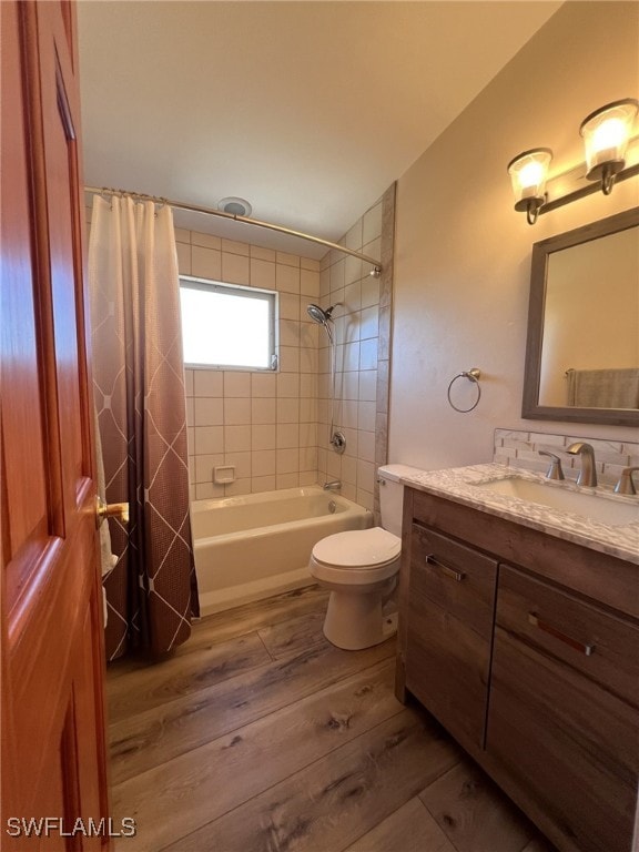 full bathroom with vanity, hardwood / wood-style flooring, toilet, and shower / bathtub combination with curtain