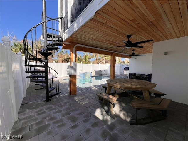 view of patio / terrace with ceiling fan and a fenced in pool