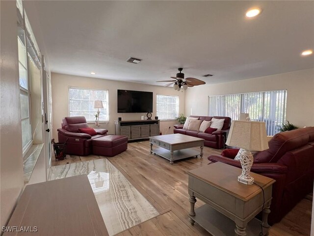 living room featuring light wood-type flooring, a wealth of natural light, and ceiling fan