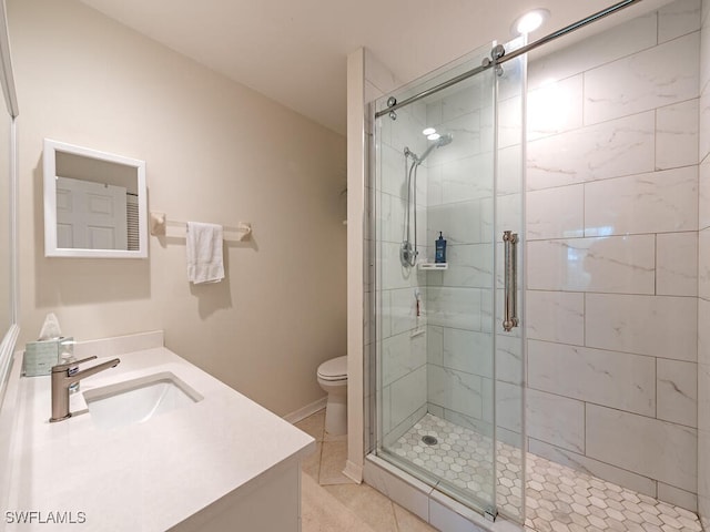 bathroom with toilet, vanity, tile patterned floors, and a shower with door