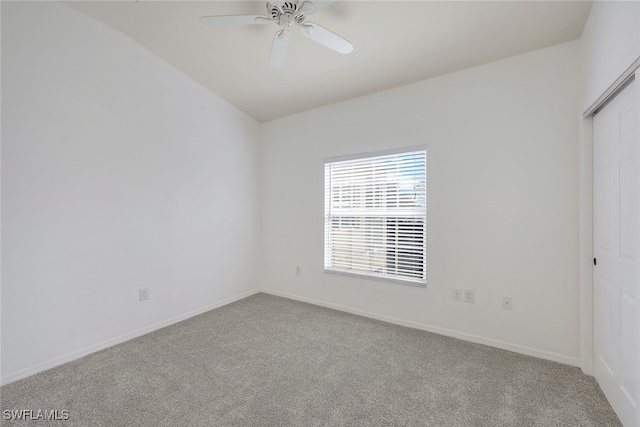 carpeted spare room with ceiling fan