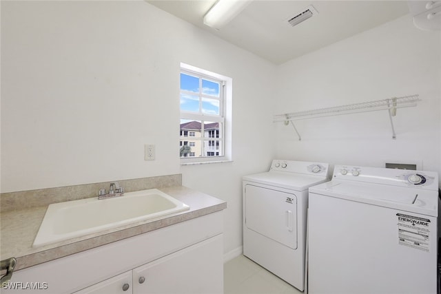 laundry room with cabinets, washing machine and dryer, sink, and light tile patterned flooring