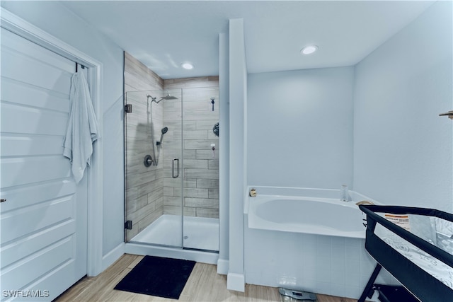 bathroom with independent shower and bath and hardwood / wood-style floors