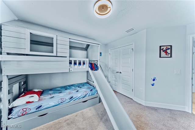 bedroom with carpet floors, lofted ceiling, and a closet