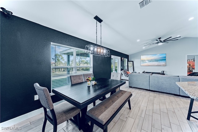 dining space with light hardwood / wood-style flooring, vaulted ceiling, and plenty of natural light