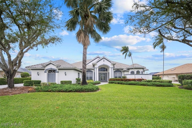 mediterranean / spanish home featuring a front lawn