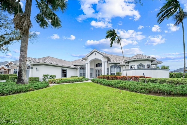 mediterranean / spanish house with a front yard