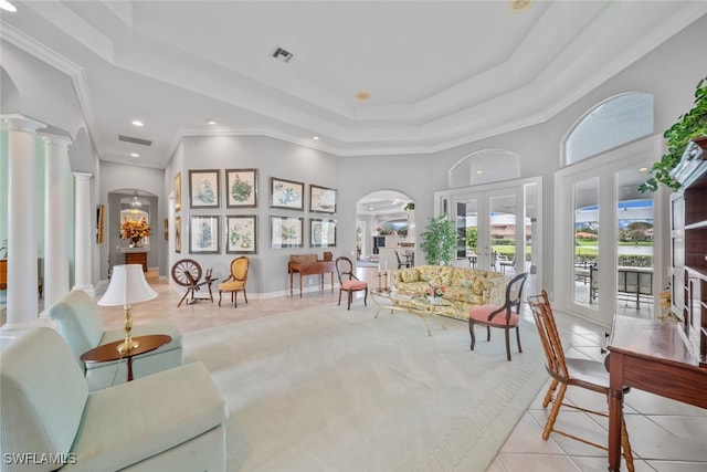 living area featuring french doors, ornamental molding, light tile patterned floors, decorative columns, and a tray ceiling