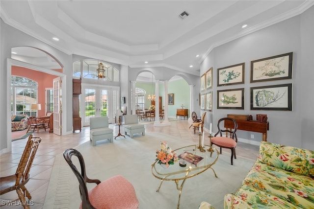 tiled living room featuring decorative columns, an inviting chandelier, french doors, and crown molding