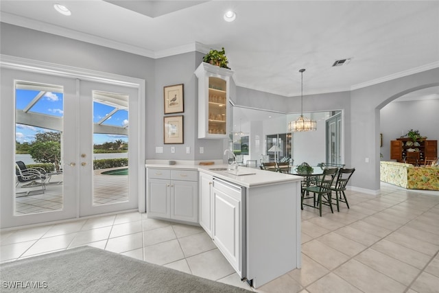 kitchen with white cabinets, ornamental molding, and light tile patterned floors