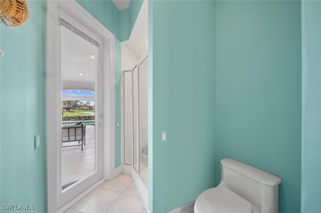 bathroom with a shower with shower door, tile patterned floors, and toilet