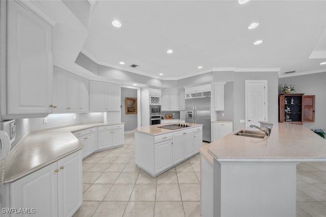 kitchen featuring built in appliances, white cabinetry, sink, and a large island