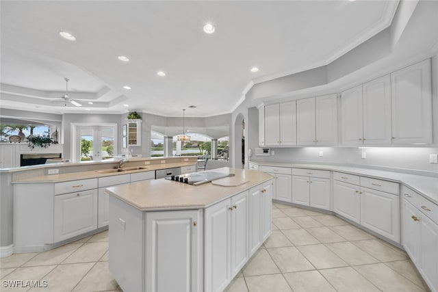 kitchen with white cabinetry, sink, a kitchen island, crown molding, and pendant lighting