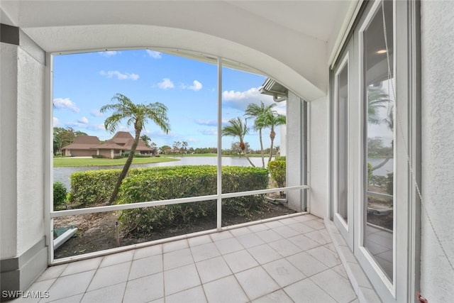 unfurnished sunroom with a wealth of natural light and a water view