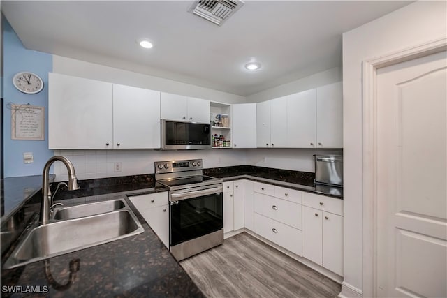 kitchen with backsplash, sink, light wood-type flooring, white cabinetry, and stainless steel appliances