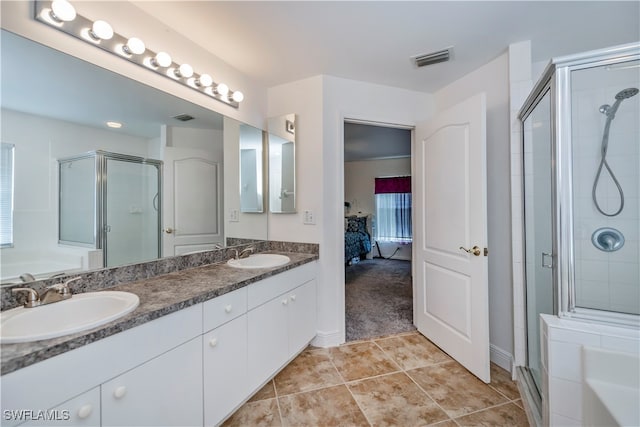 bathroom featuring shower with separate bathtub, vanity, and tile patterned floors