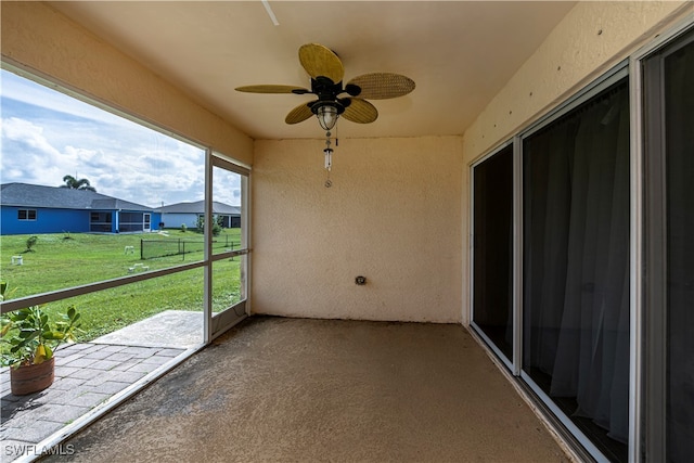 unfurnished sunroom with ceiling fan