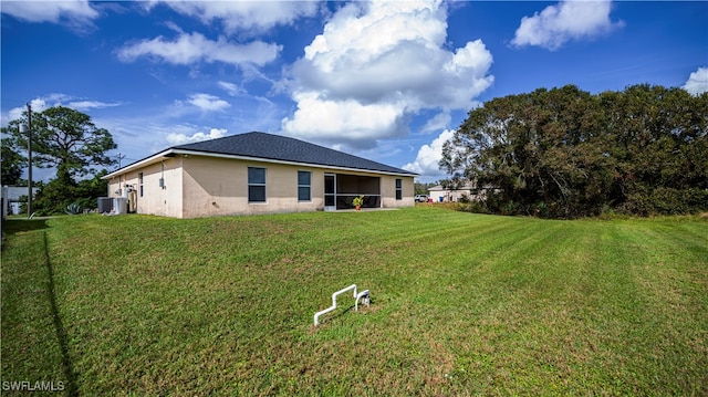 back of property with a lawn and cooling unit