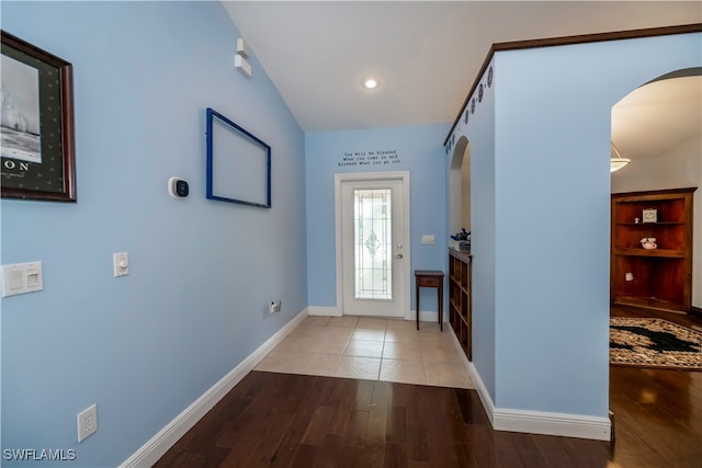 doorway featuring vaulted ceiling and hardwood / wood-style flooring