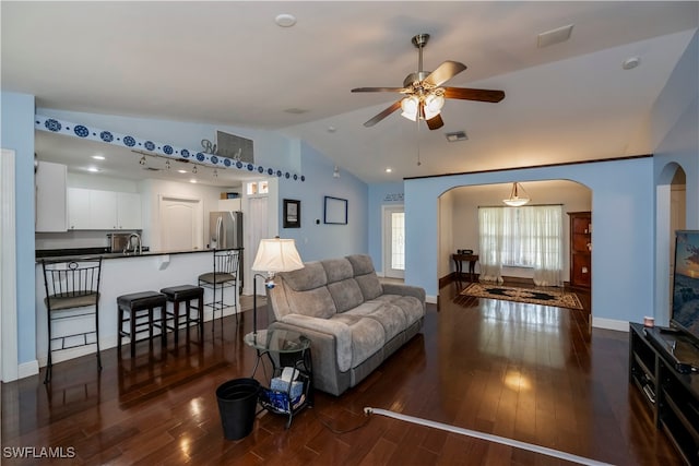 living room featuring vaulted ceiling, ceiling fan, dark wood-type flooring, and sink