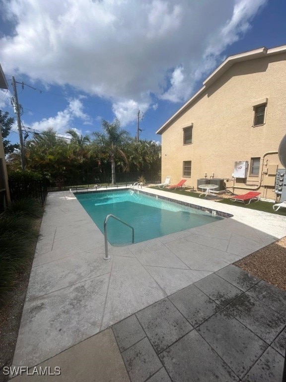 view of swimming pool with cooling unit and a patio