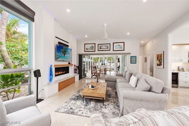 living room with a fireplace, wine cooler, and ceiling fan