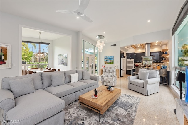 living room with ceiling fan with notable chandelier