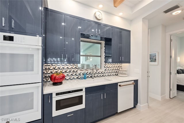 kitchen with beam ceiling, sink, tasteful backsplash, light hardwood / wood-style flooring, and white appliances