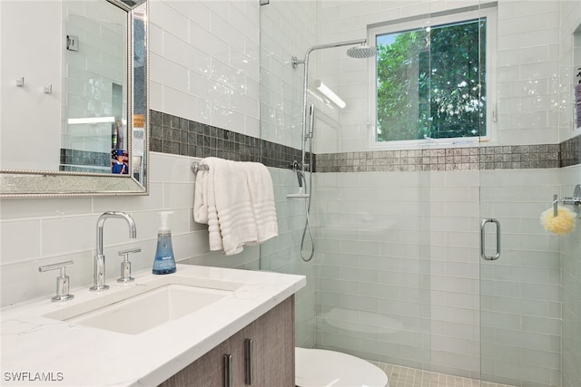 bathroom featuring tasteful backsplash, an enclosed shower, toilet, vanity, and tile walls