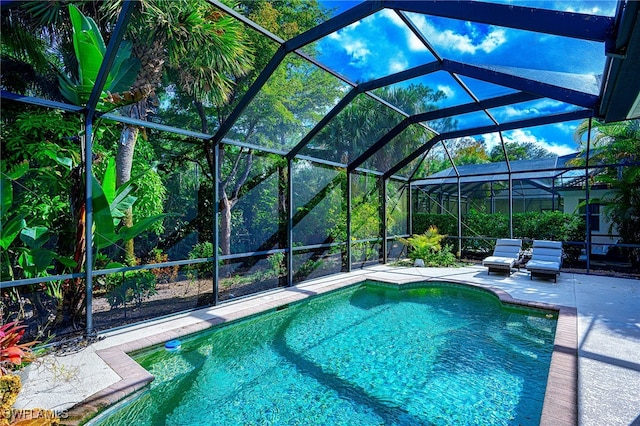 view of swimming pool with glass enclosure and a patio