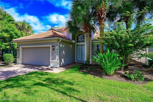 mediterranean / spanish-style home with a garage and a front yard