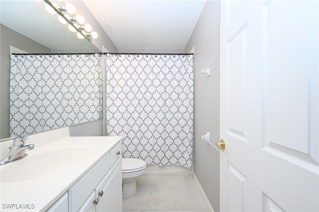 bathroom with toilet, vanity, and tile patterned flooring