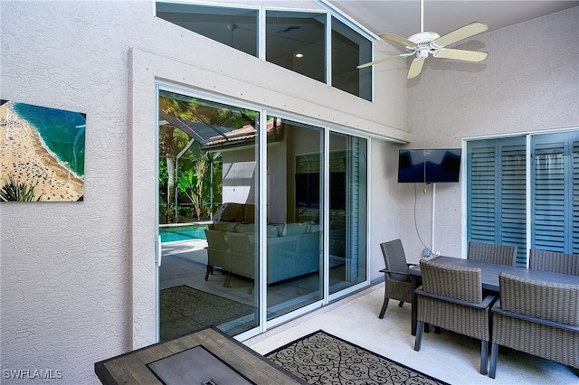 exterior space with ceiling fan and glass enclosure