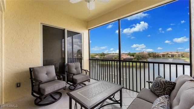 sunroom featuring ceiling fan and a water view