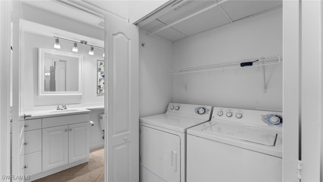 laundry area with washing machine and dryer, sink, and light tile patterned flooring