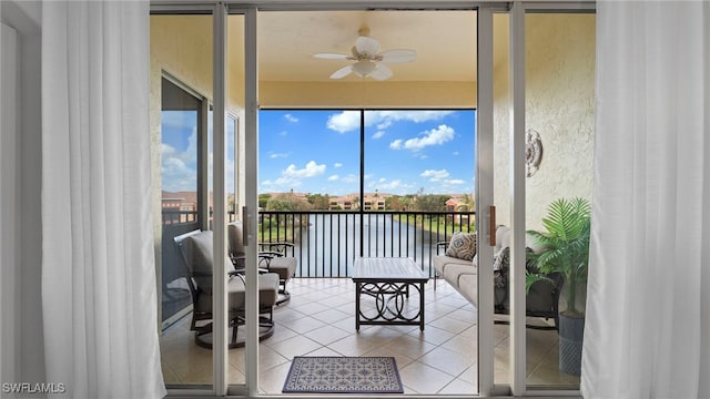 sunroom / solarium with ceiling fan and a water view